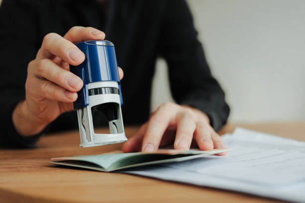 A person sealing documents with a stamp, representing Traveling Notary Services.